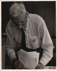 M R Chappell holding papers, guides in his shirt pocket