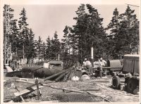 Workers next to unused pipes