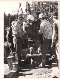 Closer image of workers around machine