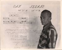 J. Goodman (not wearing glasses) standing next to various calculations on Oak Island